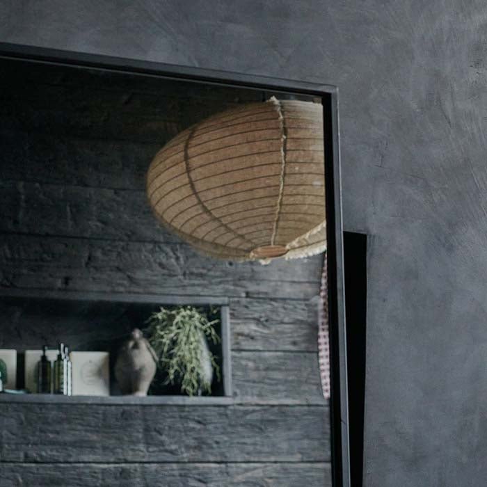 Thin black metal frame around a large rectangular mirror. Mirrors to add a reflective quality to your bedroom or bathroom. Rectangular mirror to make rooms look bigger.