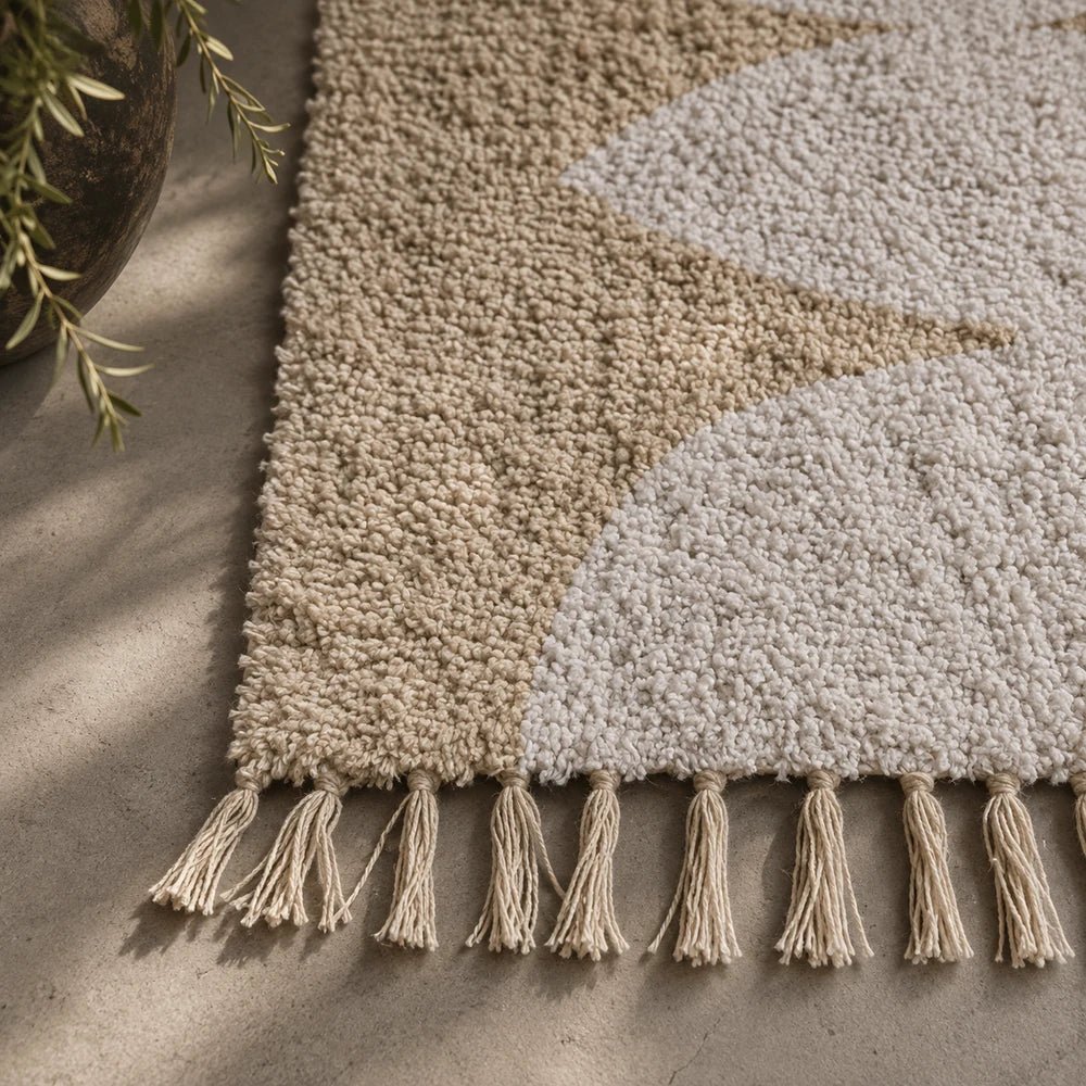 Wyatt Tufted Cotton Runner shown close up with soft cream looped texture, contrasting pale pattern and tasseled edge for a tactile neutral floor covering.