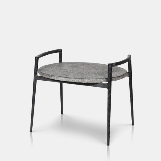 Cutout on a white background of a contemporary end table made of a stone, textured table top, with black iron legs.