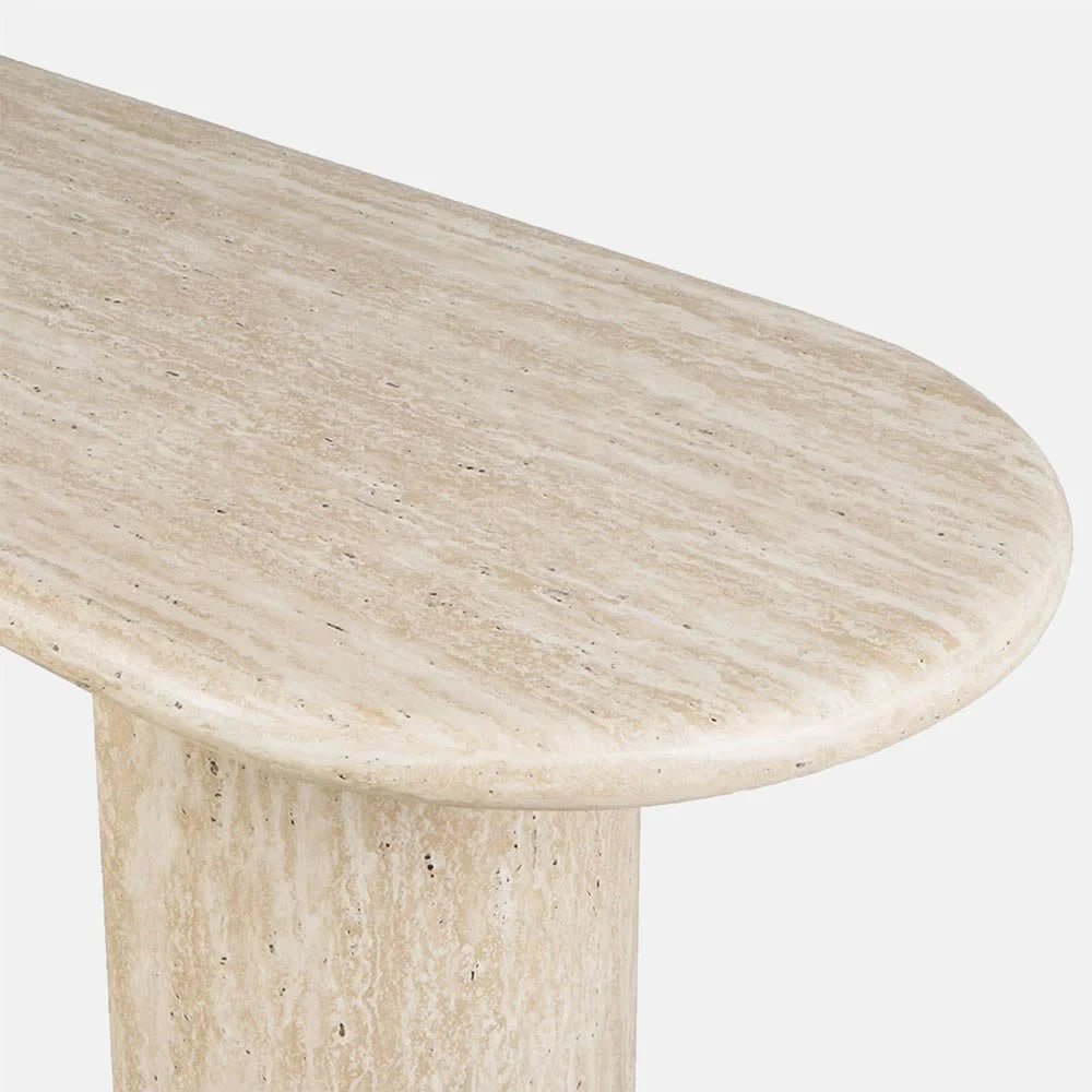 Barnard Travertine Console Table close-up showing its rounded tabletop edge, pale beige stone, natural pores and layered texture above one substantial leg.