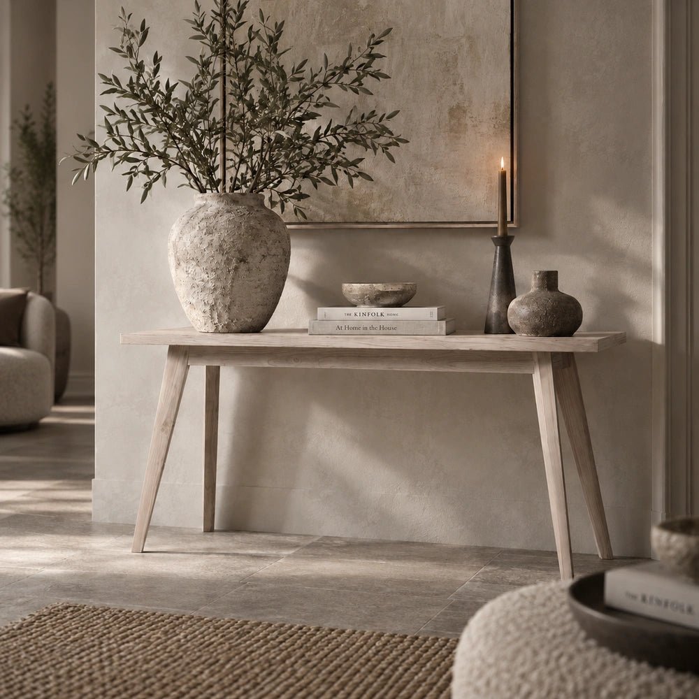 Bronson Parquet Console Table positioned behind a neutral sofa, displaying its geometric wood pattern and styled with lamps, books and decorative objects.
