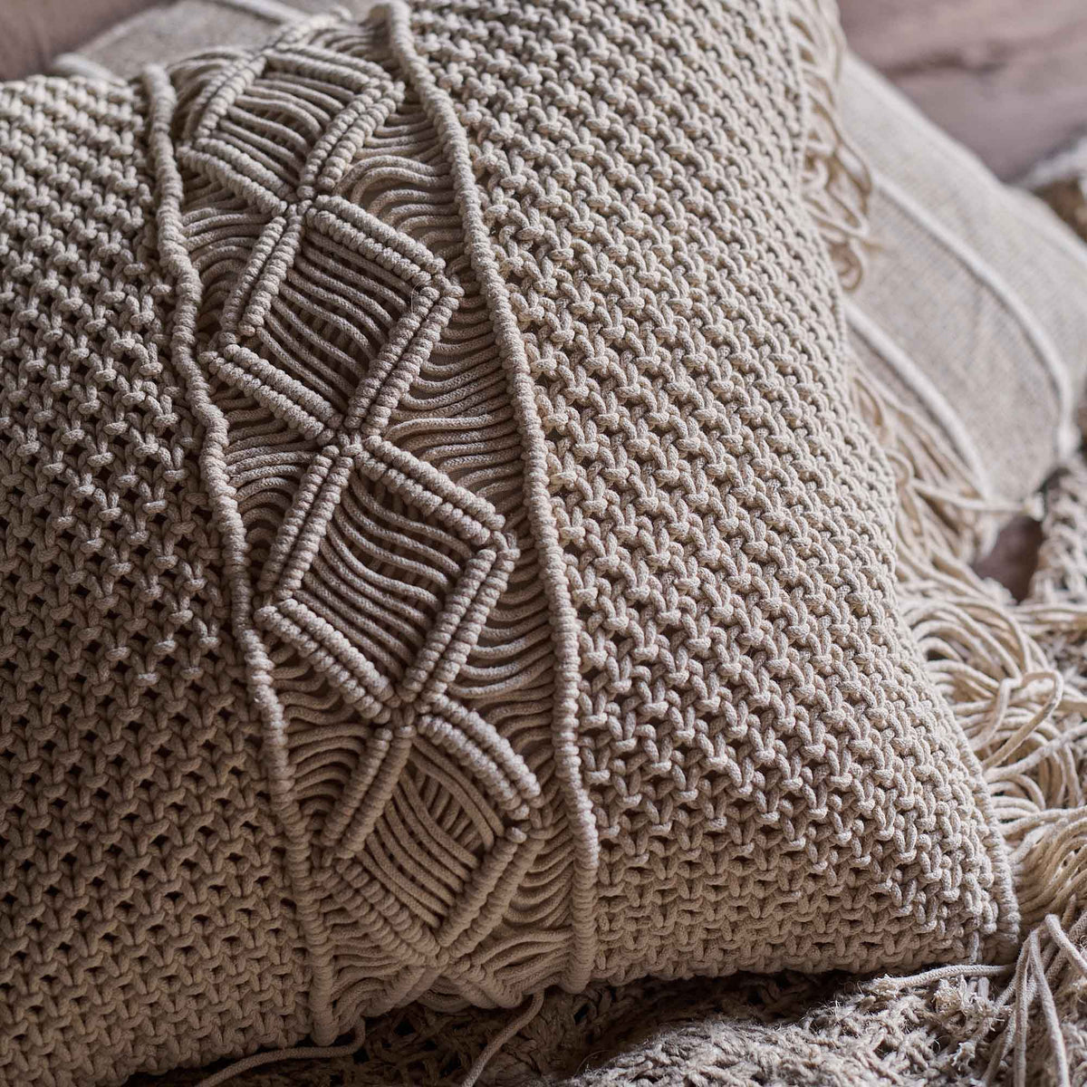 A closeup of the woven macrame front panel of the Cassidy Cushion.