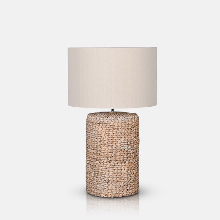 A cutout of the Celano Rope Table Lamp, a cylindrical table lamp with a chunky knotted base and a natural coloured drum shade