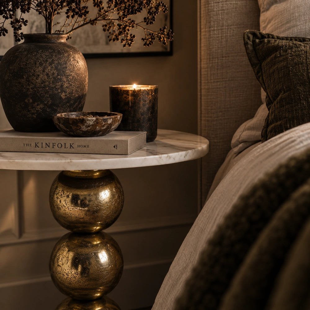 Chelsea Marble Side Table beside a cream sofa, styled with books and a candle in a warm living room with layered neutral furnishings.