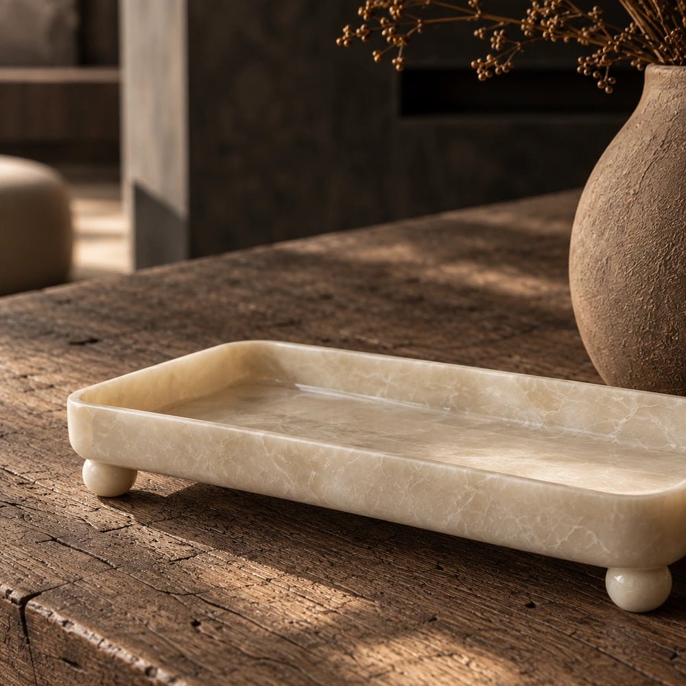 Diego Footed Tray with sculptural footed design, styled on a layered shelf with warm neutral decorative objects and contemporary natural textures.