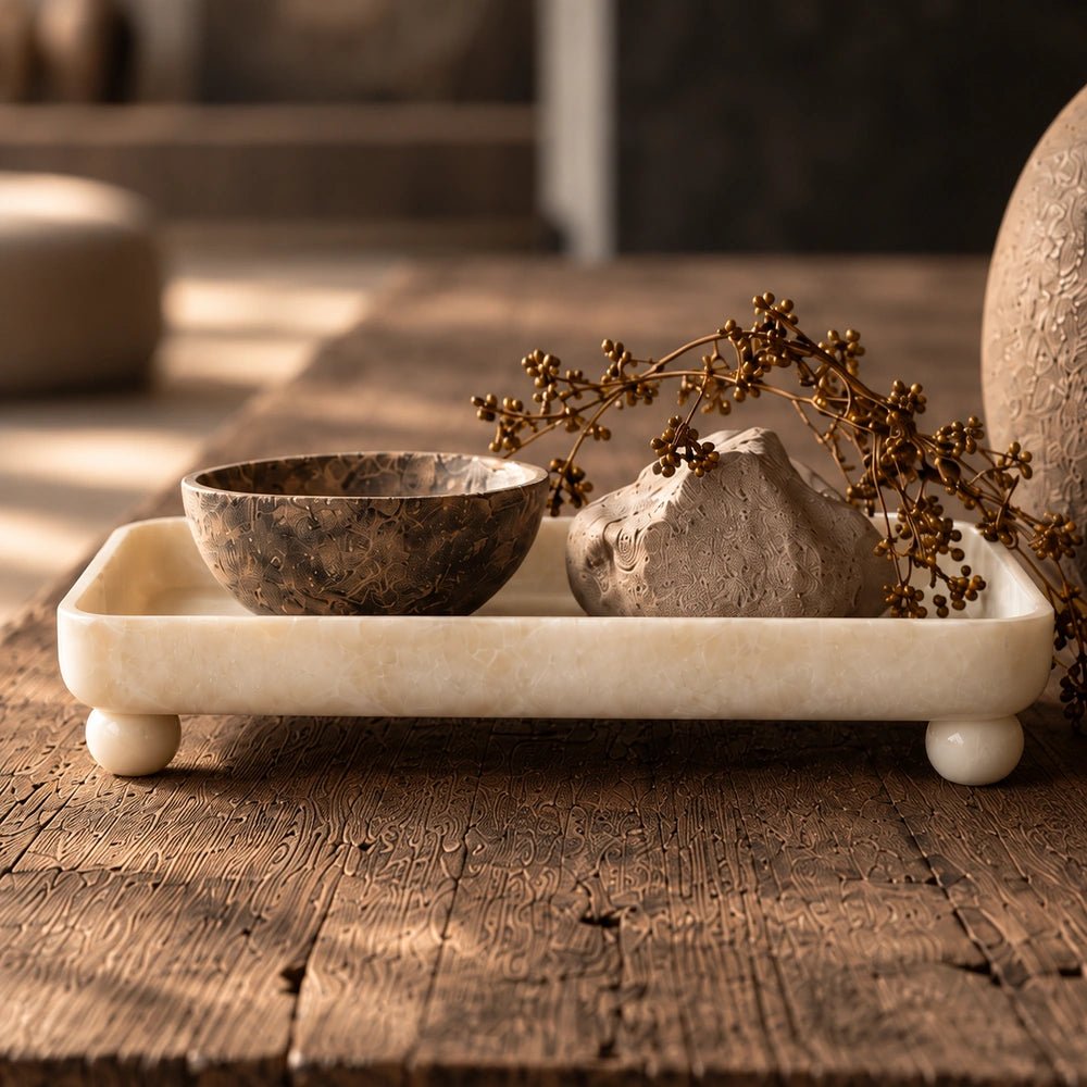 Diego Footed Tray with sculptural raised form, styled on a warm table with decorative objects, natural textures and layered contemporary interior accessories.