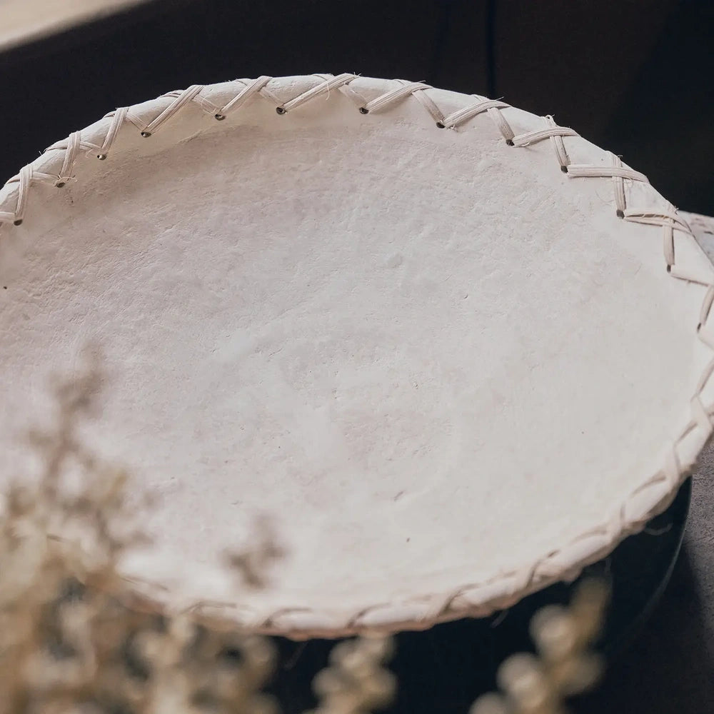 Halstead paper mache decorative bowl shown close up from above, revealing its broad off white textured interior, gently raised edge and cord lacing around the rim.