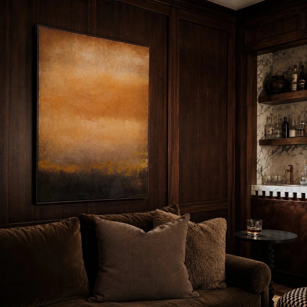 Hearst Canvas Art displayed on dark wood panelling above a brown sofa, featuring warm ochre abstract tones in a moody contemporary living room.
