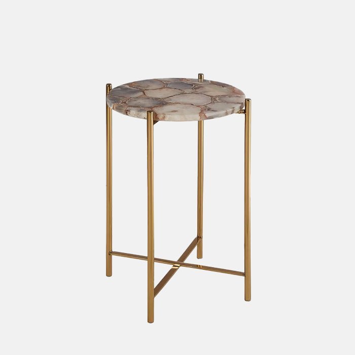 The Hexton Agate Side Table, a small round table with a top made from pinky-brown agate, with slim gold legs.