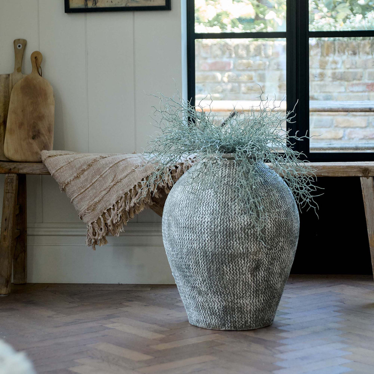 Immi Terracotta Vase, an oversized vase featuring a design of horizontal zigzag lines in dark grey against light background.
