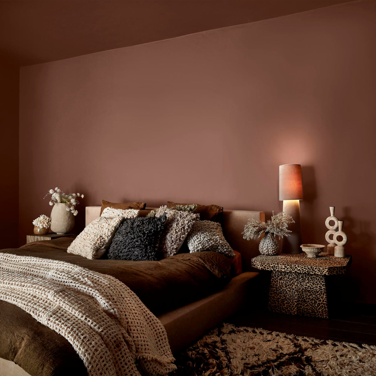 Abigail Ahern Java paint – a sumptuous warm terracotta enveloping a beautifully layered bedroom with luxurious soft furnishings