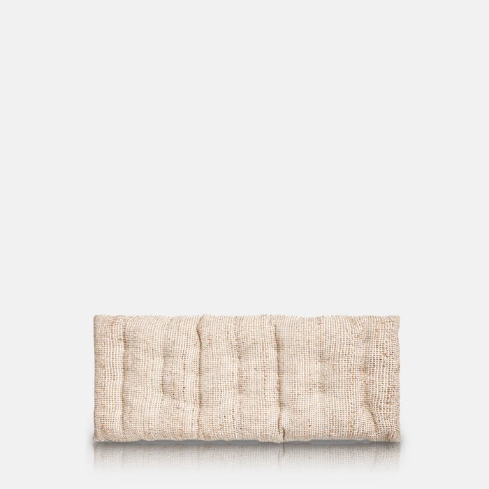 A cutout of the Konta Headboard Cushion, a long rectangular sumptuous padded cushion in woven jute and cushion.