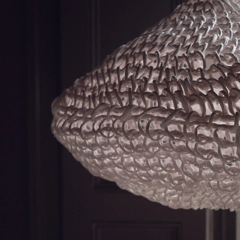 Livington Paper Rope Pendant reveals an open woven shade with looping fibres and a rounded lower edge, shown closely against a dark interior background.