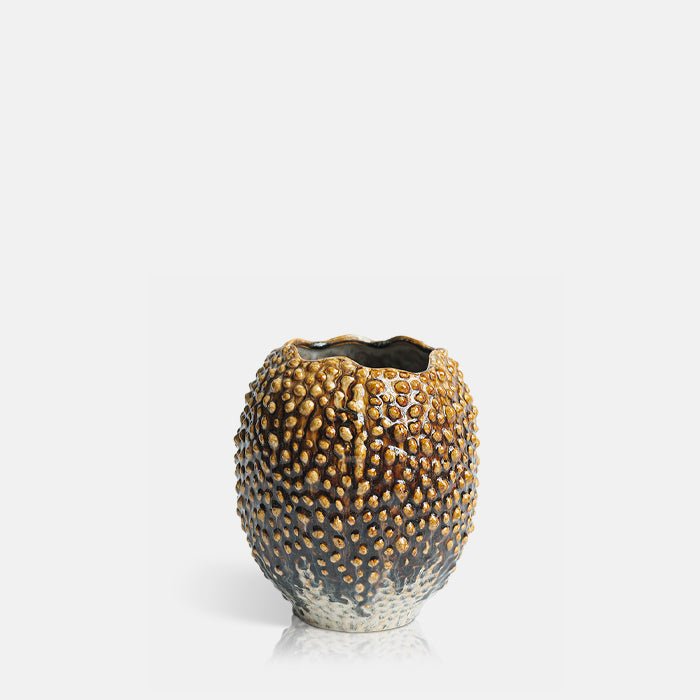 Cutout image on a white background of a round, brown vase with a raised pebble texture.