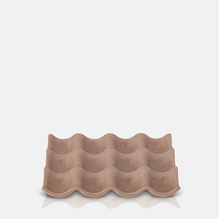 A cutout of the Moorside Egg Tray. A soft terracotta hued glazed stoneware egg tray in an intriguing organic shape.