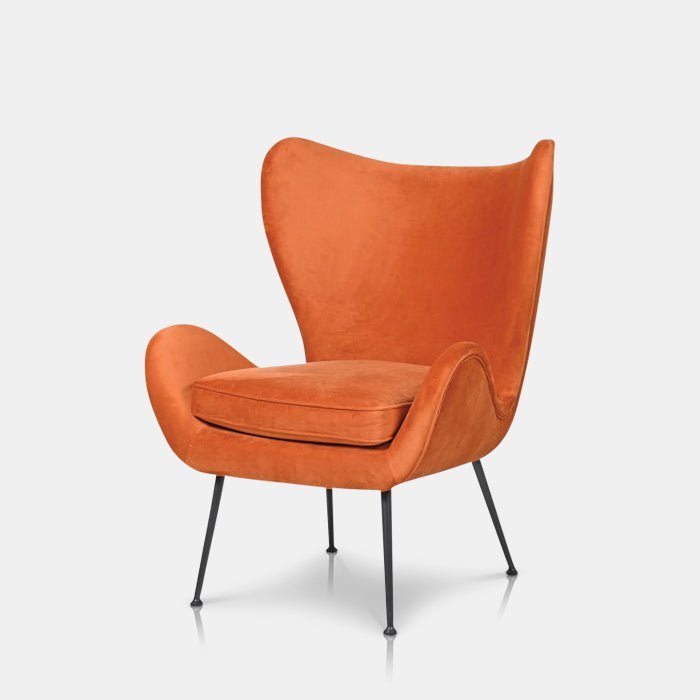 Ostra Occasional Chair, a contemporary statement chair with a curved back and slim black metal legs in a bright burnt orange.