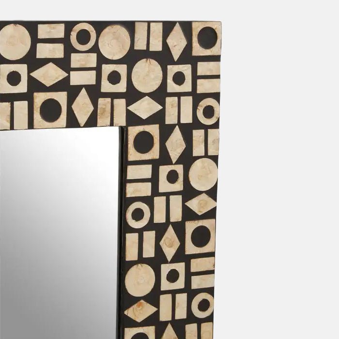 A closeup of the frame of the Palu Rectangular Mirror, showing the pearlescent effect and the pattern made of mixed shapes.