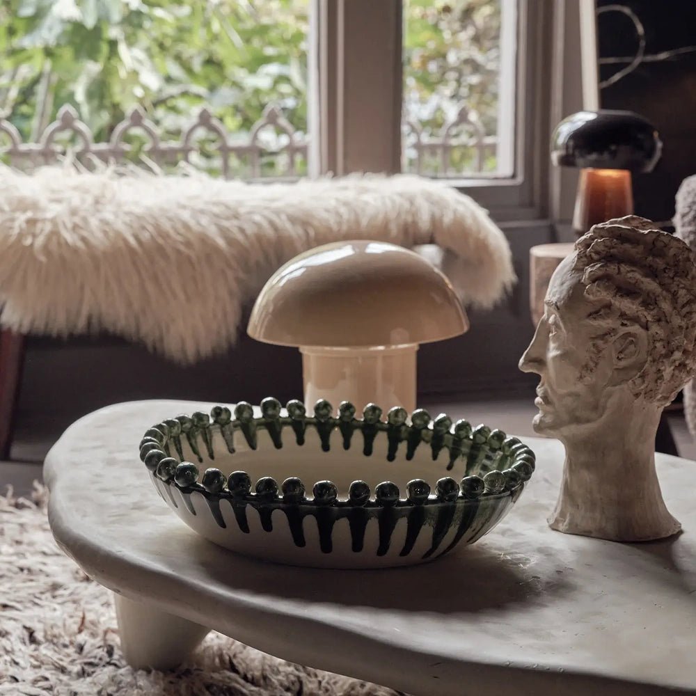 Radcliff bobble decorative bowl with green striped sides and a beaded rim, styled on a round coffee table near a window and upholstered seating.