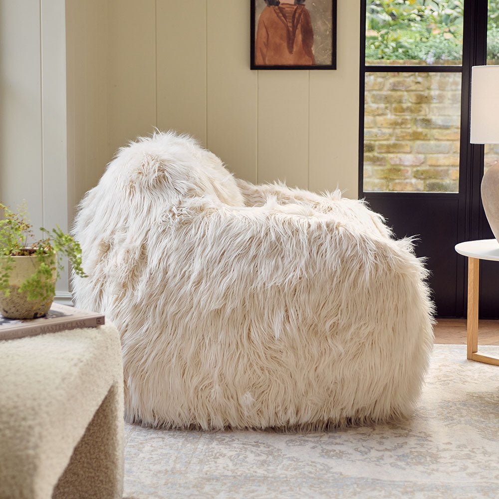 The Rowley Faux Fur Armchair, a sumptuous oversized armchair upholstered in super soft cream coloured shaggy faux fur.