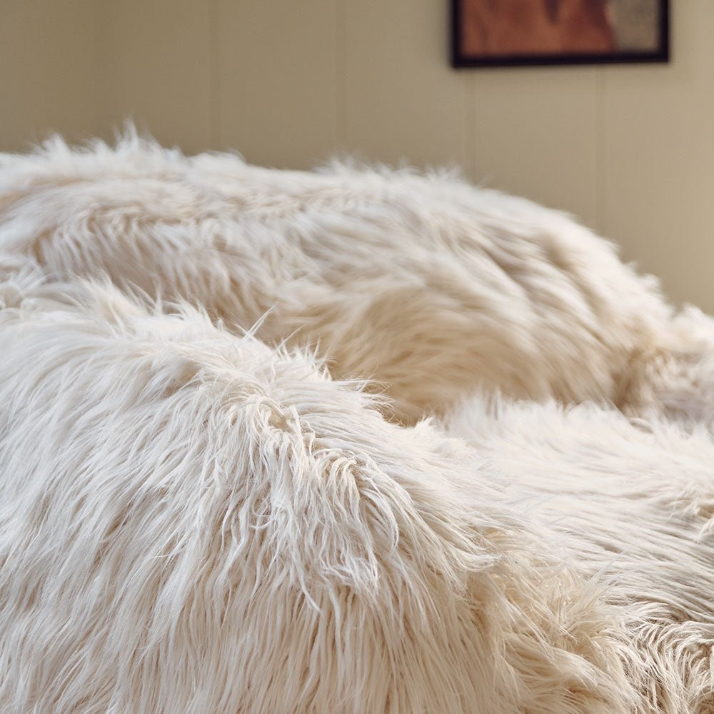 A closeup of the super soft and textural cream coloured shaggy faux fur of the Rowley Faux Fur Armchair.