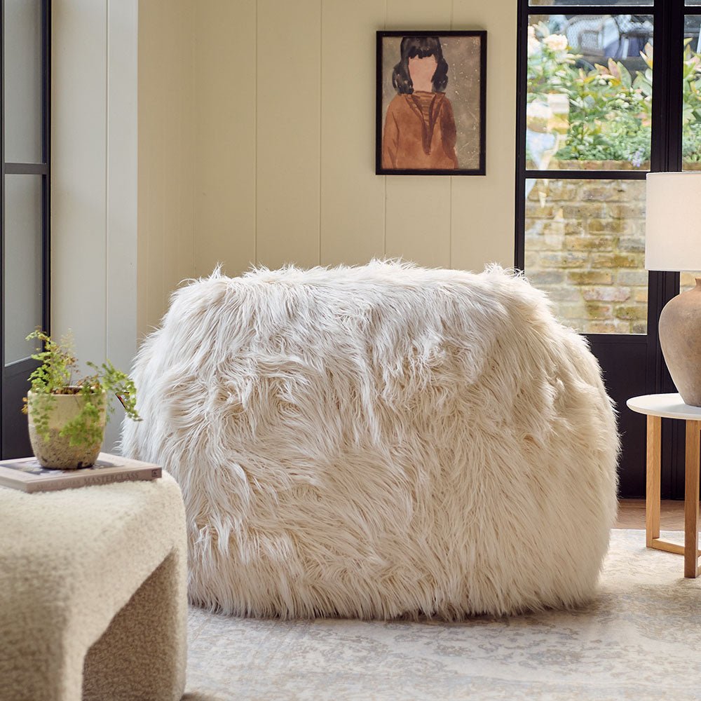 The Rowley Faux Fur Armchair, a sumptuous oversized armchair upholstered in super soft cream coloured shaggy faux fur.