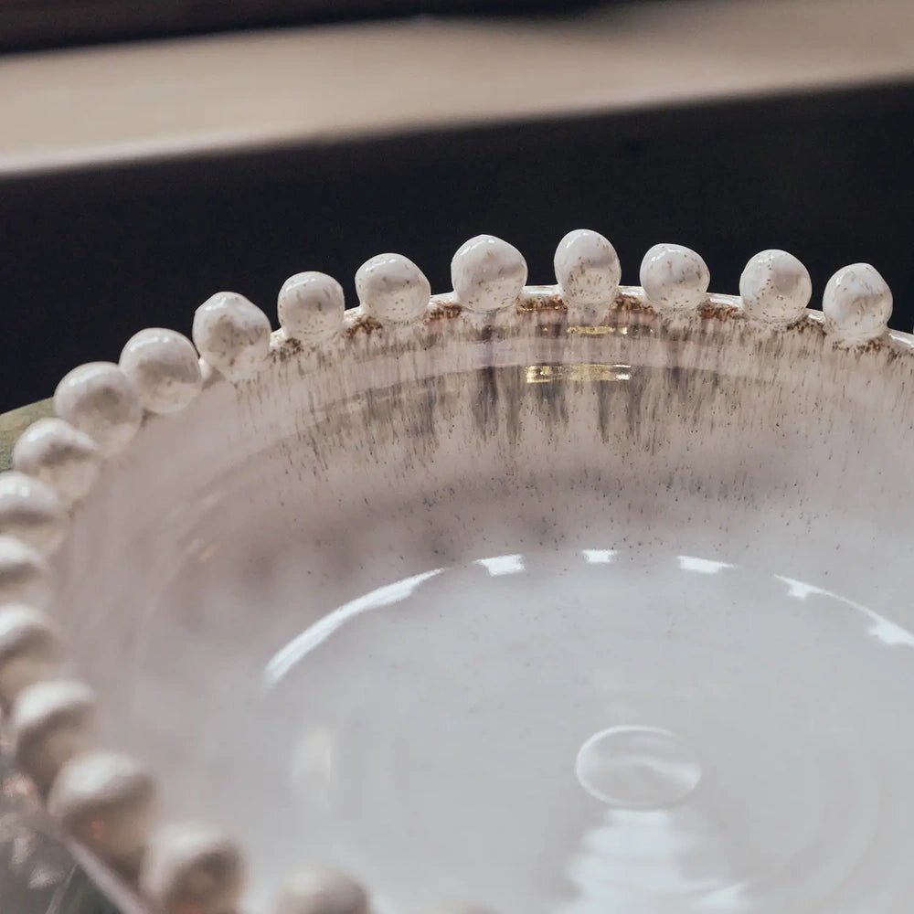 Rutledge bobble decorative bowl shown close up, highlighting rounded rim beads, a softly weathered cream edge and the smooth reflective glaze inside the bowl.