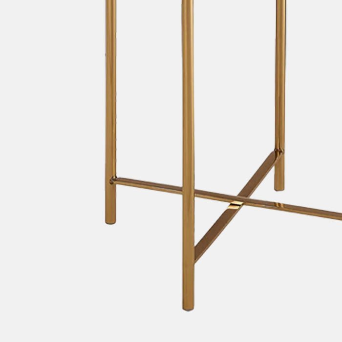 A closeup of the slim gold legs of the Sandon Quartz Side Table.