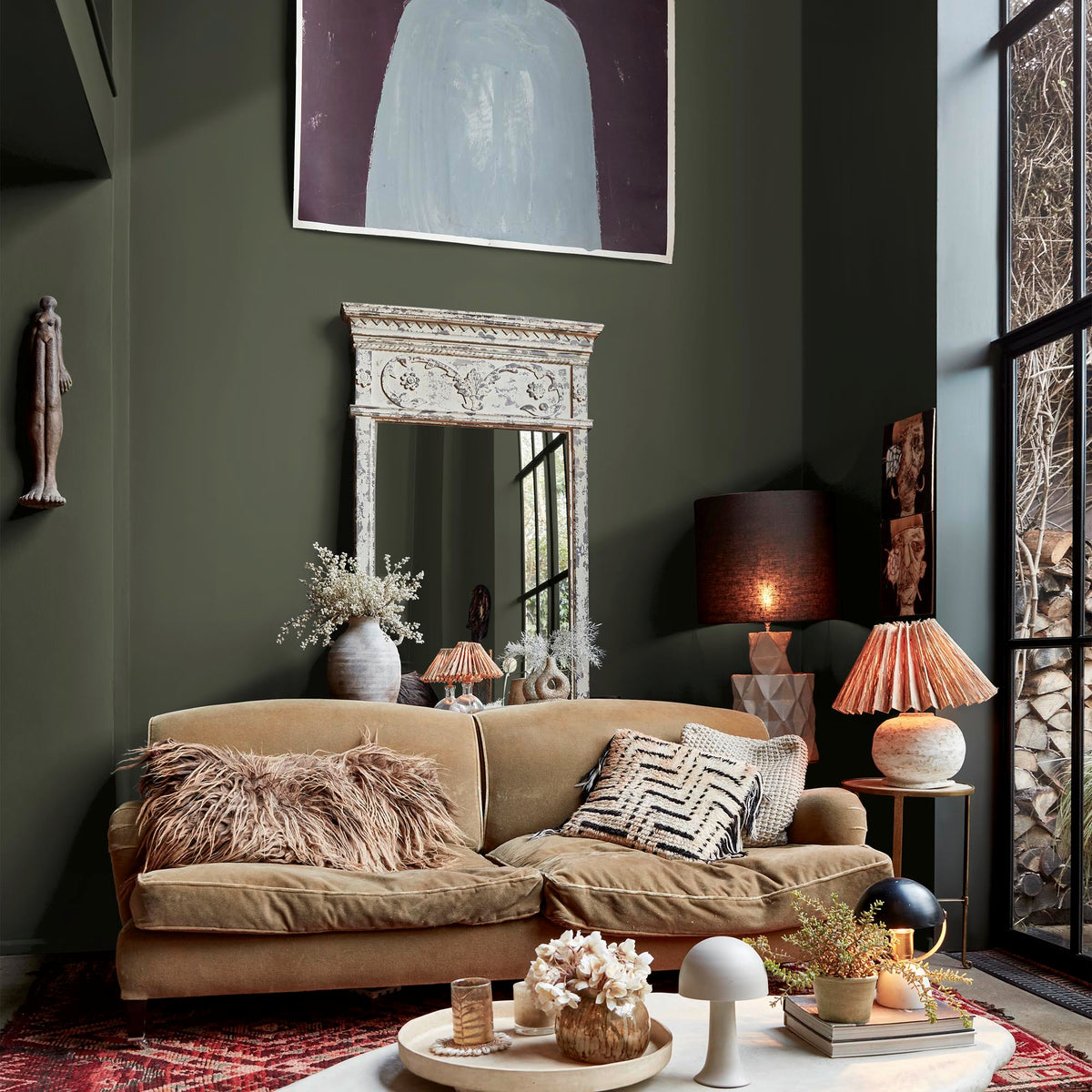 Abigail Ahern Sea Botanic paint – a sumptuous dark olive green enveloping an eclectic, richly textural living room with a deeply immersive quality