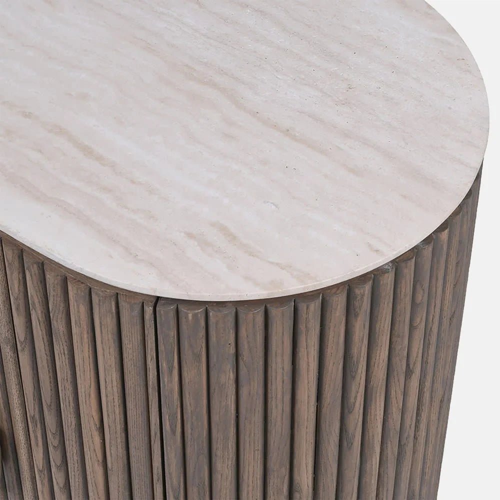 Sheridan wooden cabinet shown close up, highlighting the pale rounded top with subtle linear markings and the narrow vertical wooden slats along the curved edge.