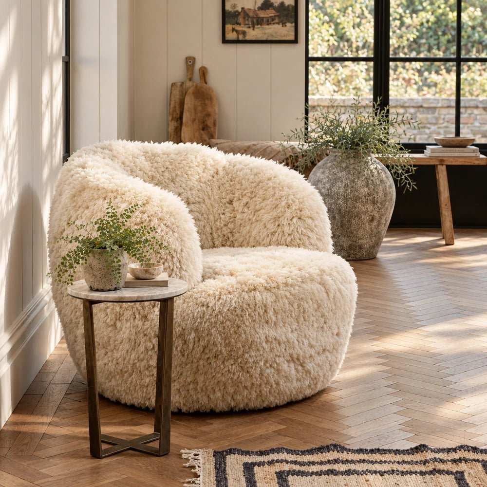 Solange Sheepskin Swivel Armchair in warm honey tones, styled in a layered contemporary room with neutral textures, sculptural furniture and decorative accessories.