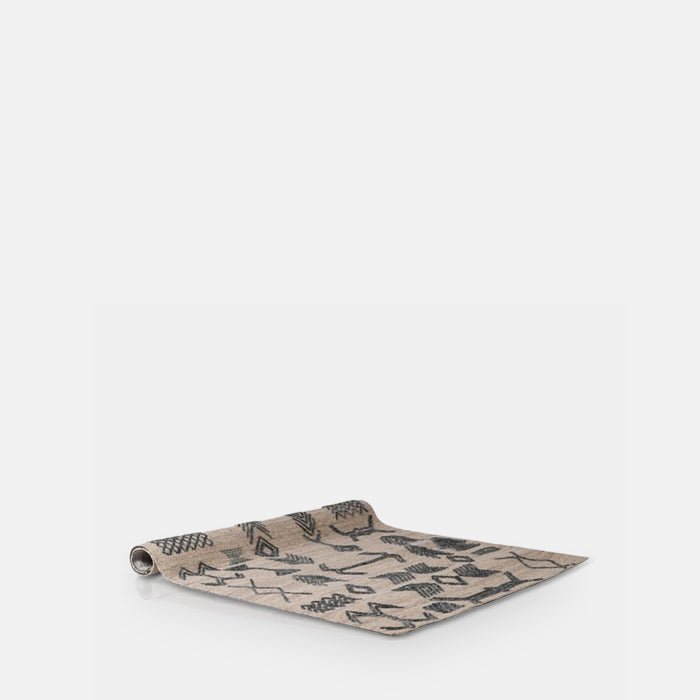 A cutout of the Tampa Wool Rug, a cream rug with a beautiful black pattern in chevron style designs