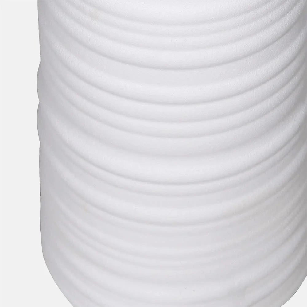 Vanderbilt ceramic floor lamp base shown close up, revealing a smooth white finish with closely spaced horizontal ridges curving around its tall tapered body.