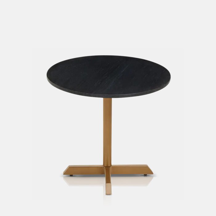 The Varana Round Side Table, with a thick black marble top and a pedestal leg in gold colour with four feet.
