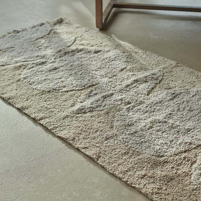 Cream tufted cotton runner with white geometric design down centre.