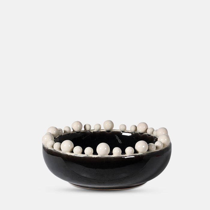 A cutout of the Bourton Bowl - Cream and Black, a large round bowl with a glossy glazed finish and textural bubble top.