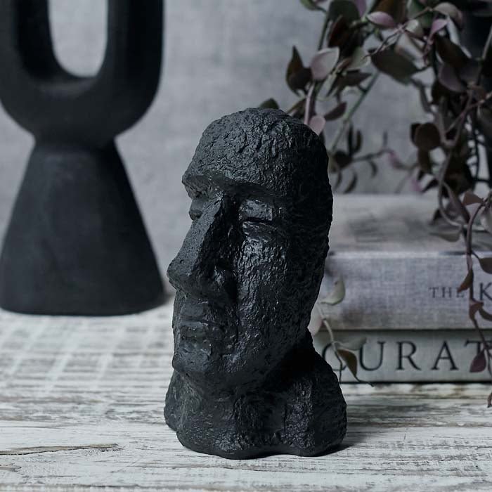 Face and shoulders sculpture looking to the side sat on a wooden table