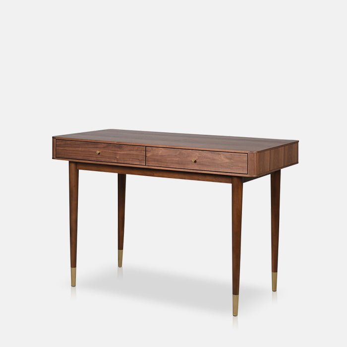A cutout of the Winslow Desk, a mid century style wooden desk in warm brown finish, with gold detailing.