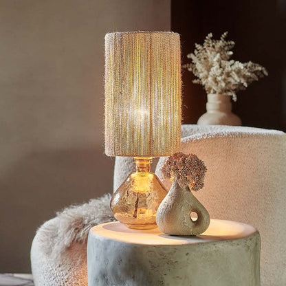 Warm light glowing through a woven rattan lamp shade and amber glass base.
