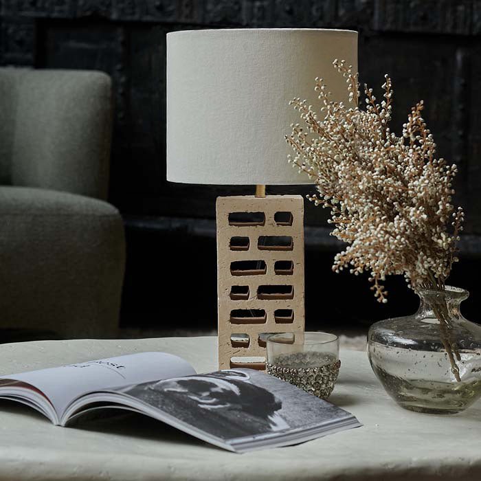 Table lamp with white shade and recycled brick base.
