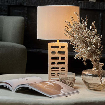 Table lamp with recycled beige breezeblock base and white drum shade.