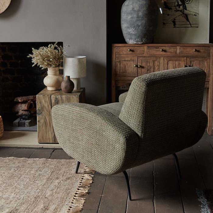 Green-grey upholstered lounge chair in sculptural modern design.