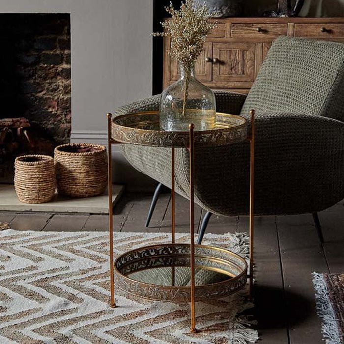 Vintage looking mirrored drinks table with two-tier design, bronze finished frame and reflective glass removable tray surfaces, style as a statement side table in a cool  living room 