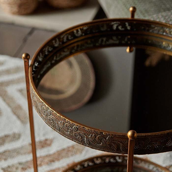 A closeup of the Ritson Mirrored Side Table, a two tiered round mirrored tray table top with a bronze frame.