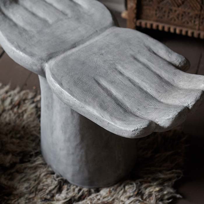 Textured grey and white surface of a hand shaped stool