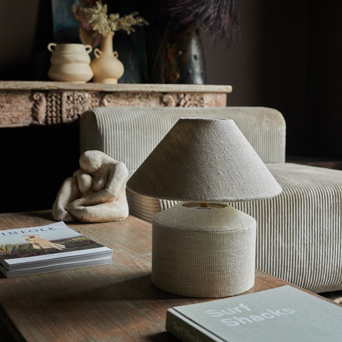 A cream linen table lamp styled on a coffee table to add a chic designer look to your home decor. Small table lamp made from cream fabric.