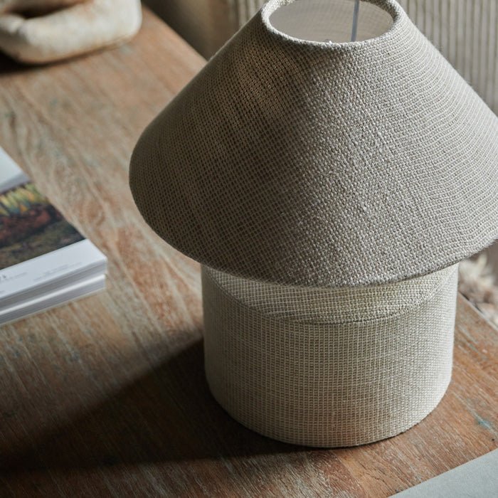 Table lamp covered in off-white linen fabric. Fabric table lamp in a neutral colour looks amazing styled against dark accessories. 