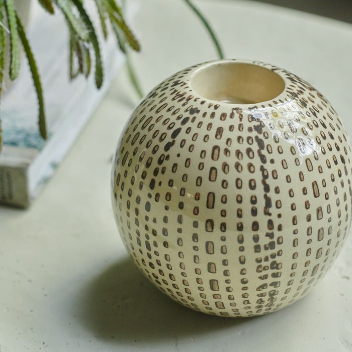 Brown dotted pattern on a cream spherical candleholder