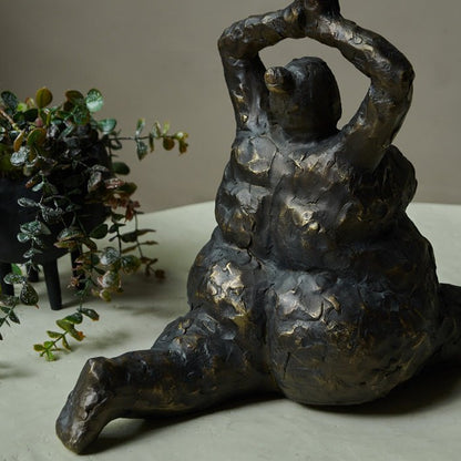 Back view of a resin figurative sculpture, with antique metal-look finish. Female figure in a yoga pose with stretched legs and raised arms. Unique accessories for your home.