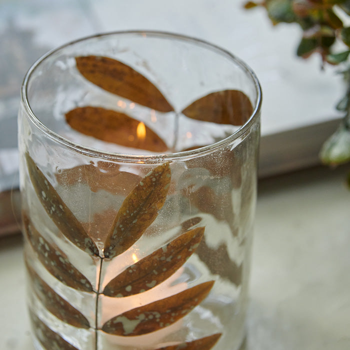 Dried leaf adorning a clear glass tealight holder.