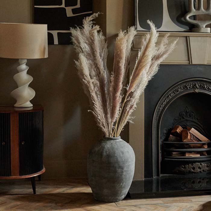 Large grey vase filled with a big bunch of dried pampas grass
